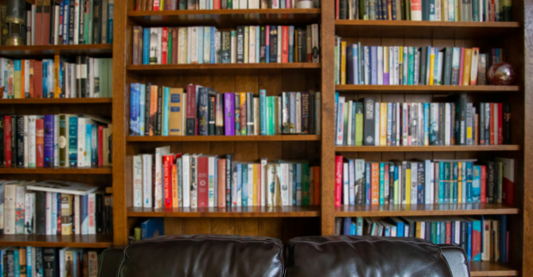 multiple rows of bookshelves with multi-colored books on them