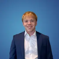 A young man wearing a white shirt and dark suit jacket